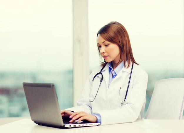 Geneeskunde en gezondheidszorg concept - drukke arts met laptopcomputer