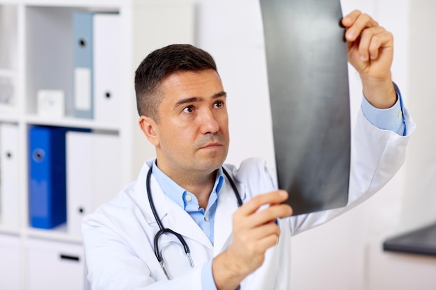 Foto geneeskunde gezondheidszorg en mensen concept mannelijke arts of chirurg met röntgen in het ziekenhuis