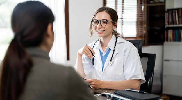 geneeskunde gezondheidszorg en mensen concept vrouwelijke arts in gesprek met vrouwelijke patiënt in het ziekenhuis