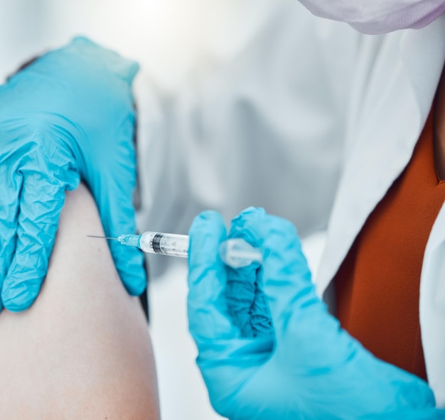 Geneeskundegezondheidszorg en arts die een covid-vaccin doen op een patiënt in het ziekenhuis tijdens pandemie Close-uphanden van een medische professional met handschoenen die een antilichaaminjectie doen met spuit in de kliniek