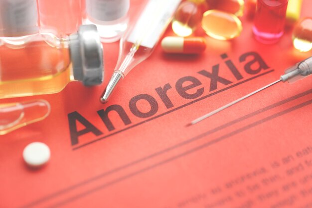 Foto geneesmiddelen en anorexia-diagnose geschreven op papier close-up