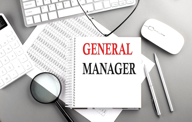 GENERAL MANAGER text on notepad on chart with keyboard and calculator on grey background