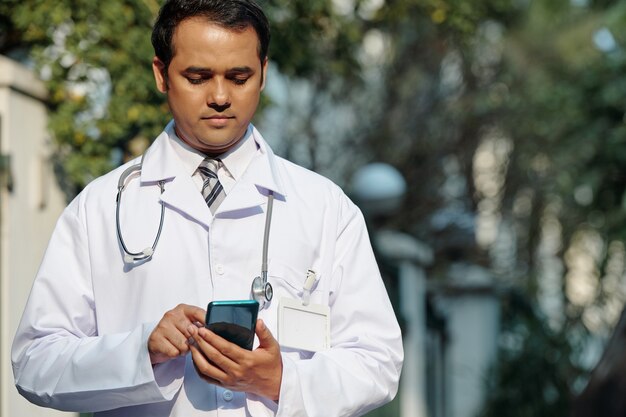 General practitioner checking phone