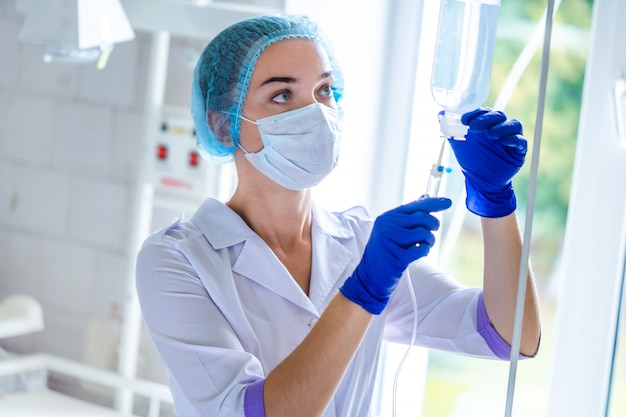 General practitioner is preparing drop counter to a patient for procedure in hospital