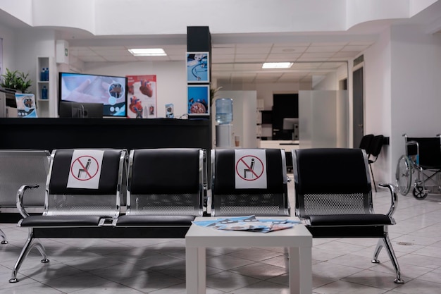 Photo general shot of empty hospital waiting area. sectioned seats to prevent covid 19 infection at no people health professional office. unoccupied medical clinic reception lobby.