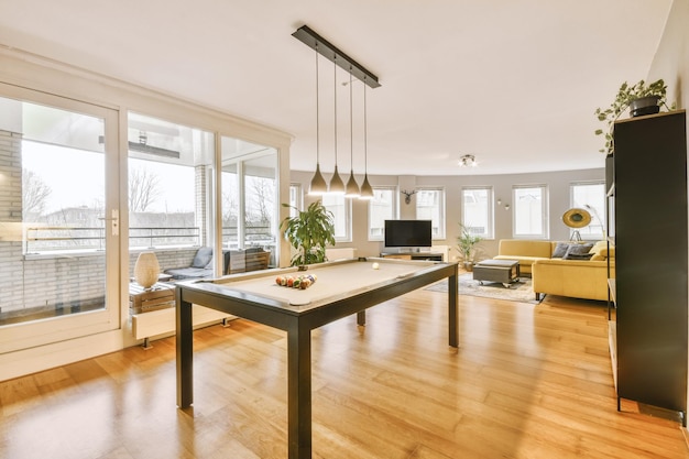 General view of the dining area with modern furniture and access to a glazed balcony in a cozy apartment