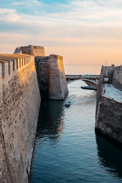 배가 그것을 건너는 동안 해가 질 때 Ceuta의 Royal Walls의 해자의 일반적인 보기. 고품질