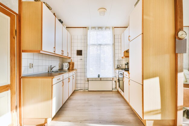 General view of a small corner kitchen on the parquet floor of a modern house