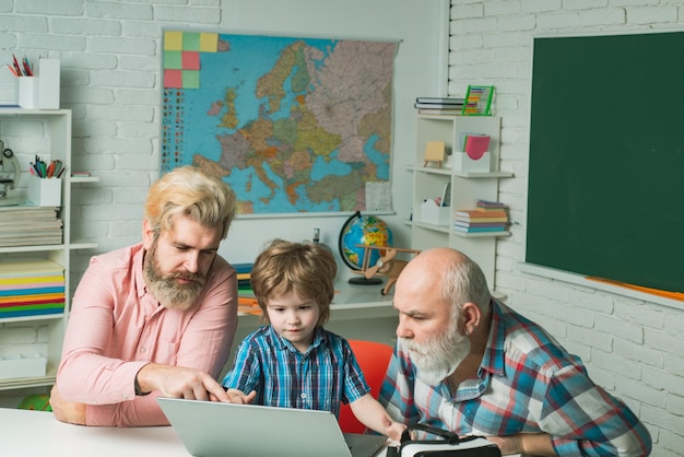 Generatie van mensen en stadia van opgroeien Senior man met behulp van een laptopcomputer met zijn zoon en gr