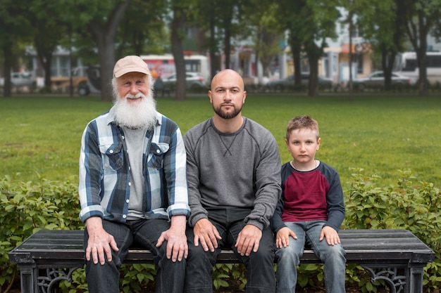 generaties mannen zitten in een park op een bankje