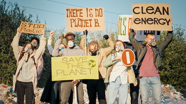 Photo generation care about the futuregroup of volunteers in gas masks with a poster calling to take care ...