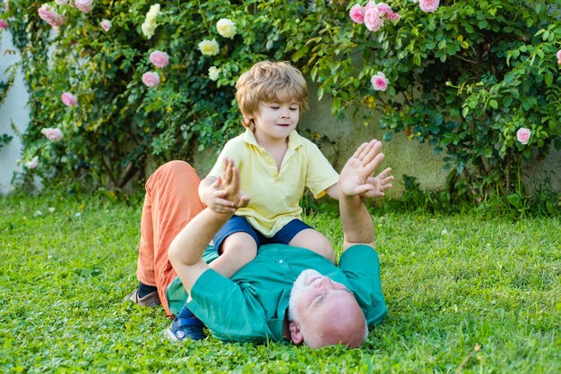 Generation of people and stages of growing up Two generation weekend together Retirement parent Senior man with grandson jogging in park Family tradition