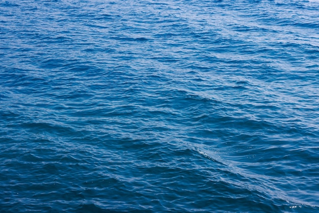 Generisch grenzeloos zeewateroppervlak, overdag alleen blauw water met milde rimpelingen