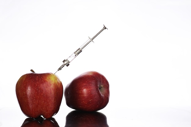 Genetically modified foods, apple pumped with chemicals from a syringe