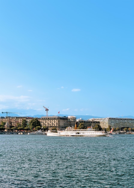 Geneva, Switzerland - August 30, 2016: Steam boat in the water in Geneva Lake seen from the embankment of Promenade du Lac in summer, Geneva, Switzerland. People on the background