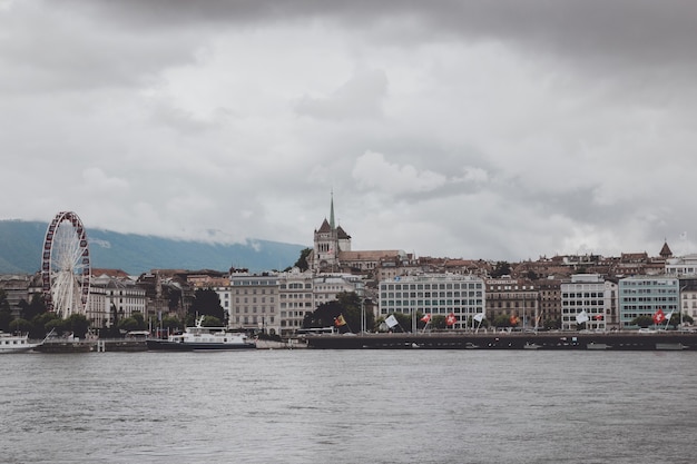 Geneva, Switzerland - July 1, 2017: View on Geneva lake, far away mountains and city Geneva, Switzerland, Europe. Summer landscape, sunshine weather, dramatic cloudy sky