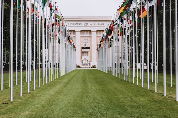 Genève, Zwitserland - 1 juli 2017: Nationale vlaggen bij de ingang in het VN-kantoor in Genève, Zwitserland. De Verenigde Naties werden in 1947 in Genève opgericht en zijn het op één na grootste VN-kantoor