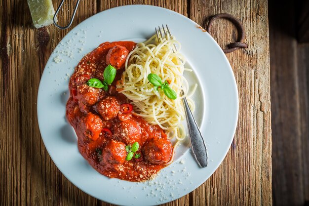 Geniet van je spaghetti bolognese met gehaktballen en parmezaan