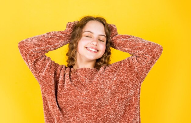 Geniet van zijdeachtig haar Mooi klein model Gezonde krullen Gemakkelijk kapsel Schoonheidsbenodigdheden Krullend haar perfect ontwarren Mooi meisje krullend haar gele achtergrond Kapsalon Schattig klein kind