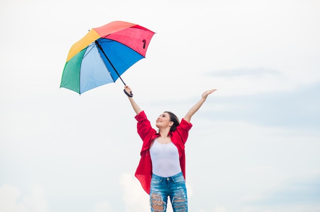 Genieten van de herfstdag zorgeloze tijd doorbrengen met regenachtig weer Herfst positieve stemming herfst mode Regenboog paraplu bescherming mooie vrouw met kleurrijke paraplu herfst weersvoorspelling