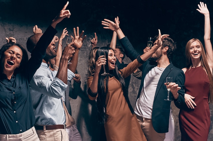 Foto genieten van een geweldig feest. groep mooie jonge mensen die dansen met champagnefluiten en er gelukkig uitzien