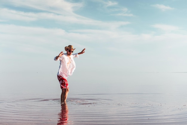 Genieten van een majestueus uitzicht man in hoed en vrijetijdskleding loopt op het meer op het eiland jarilgach, oekraïne