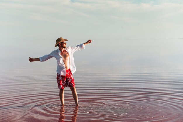 Genieten van een majestueus uitzicht Man in hoed en vrijetijdskleding loopt op het meer op het eiland Jarilgach, Oekraïne