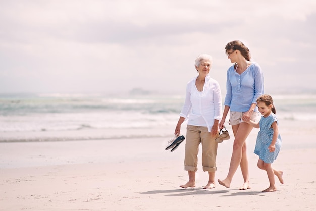 Genieten van een meidendagje Portret van een vrouw met haar dochter en moeder op het strand