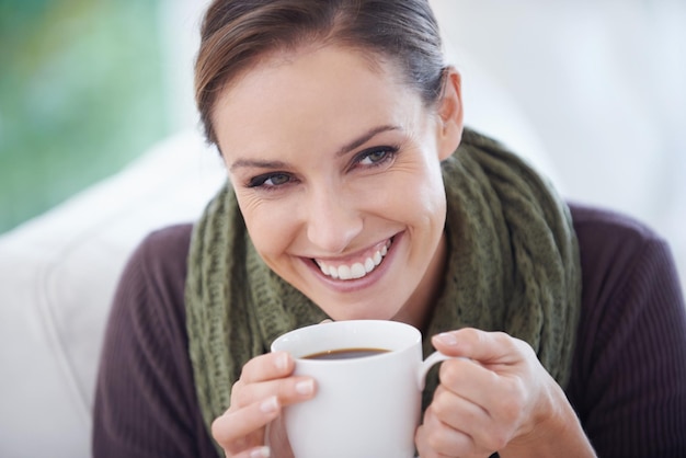 Genieten van het frisse aroma Een jonge vrouw die vrolijk lacht terwijl ze een kopje koffie close-up vasthoudt