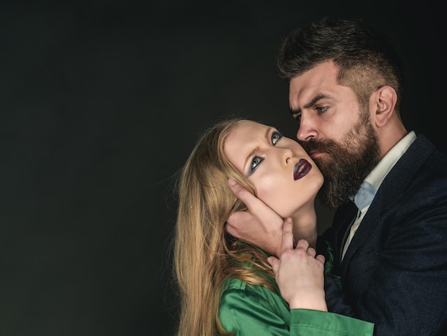 Genieten van het sensuele leven Verliefde paar Stijliconen Bebaarde man knuffel vrouw met lang haar Intiem paar in mode kleding Mode stijl en haarverzorging Ze houden allebei van mode kopie ruimte