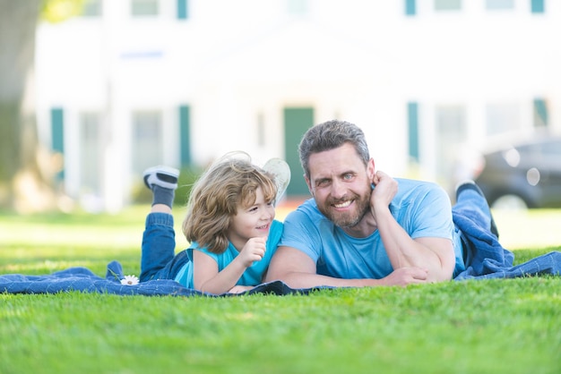 Genieten van rust en ontspanning. Gelukkige zoon en vader ontspannen op deken. Familie vrije tijd. Zomervakantie. Jeugd en ouderschap.