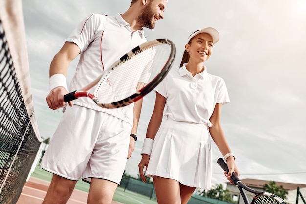 Genieten van tijd doorbrengen op de baan, een jong stel gaat tennissen