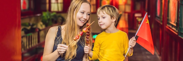 Genieten van vakantie in china gelukkige toeristen moeder en zoon met een chinese vlag en met traditioneel