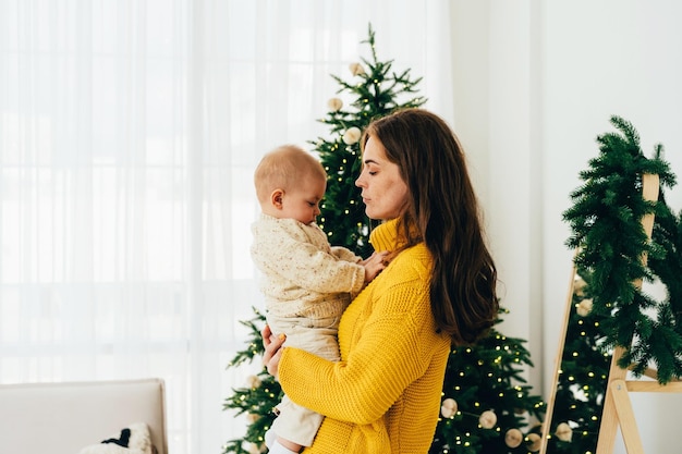 a gentle attentive contented mother holds a one-year-old child in her arms