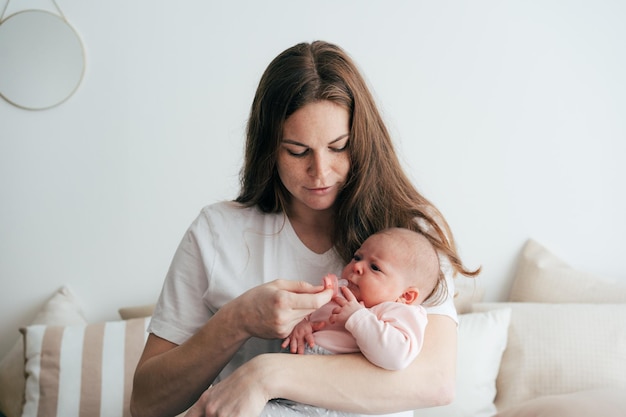 gentle caring mother holds a newborn baby in her arms