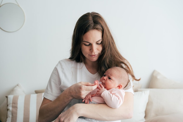 Photo gentle caring mother holds a newborn baby in her arms