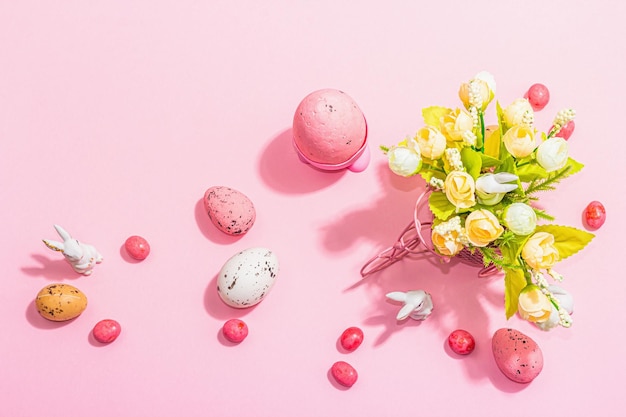 春の花ウサギの卵と伝統的な装飾が施された穏やかなイースター グリーティング カード ハッピー ホリデー コンセプト ハード ライト ダーク シャドウ ピンク背景上面図
