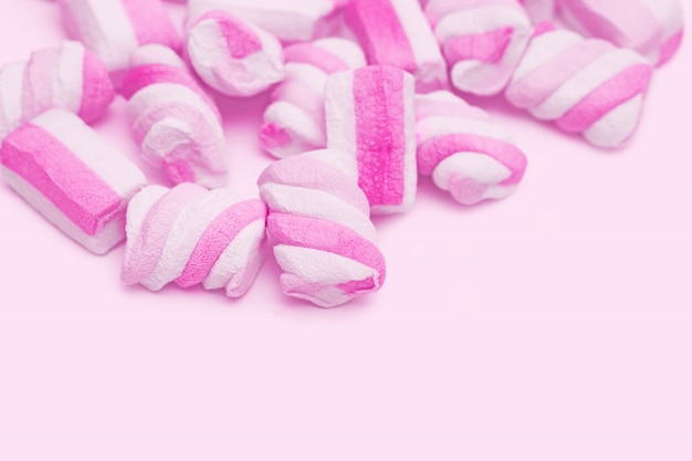 Photo gentle pink and white color marshmallows on pink with copy space