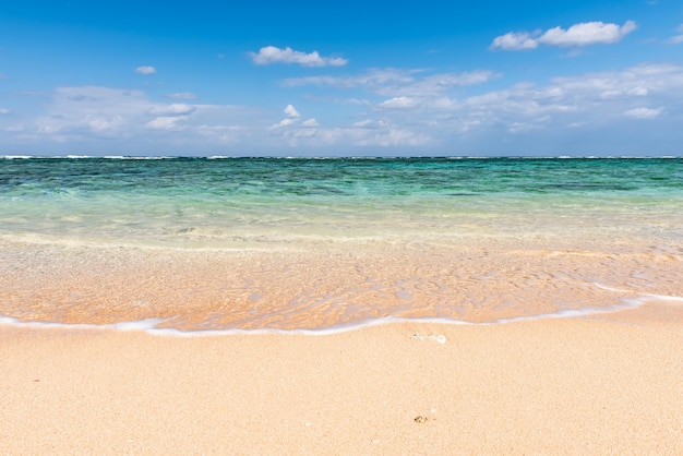 Gentle turquoise sea wave on clean sand beach