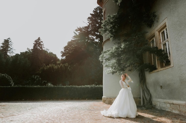 нежно невеста в кружевном платье на фоне стены в саду