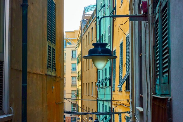 Genuese smalle oude straat met oude straatlantaarn aan de muur, Genua, Italië