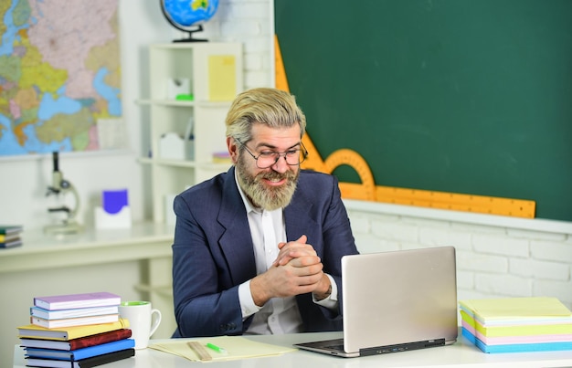 Genuinely learned man. Bearded man work on computer. Elderly man back to school. School teacher. University professor. Man of science. New technology. Innovative teaching methods and webinars.