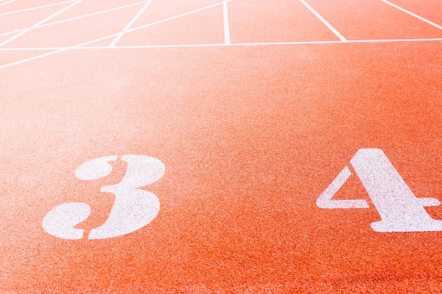 Genummerde startbaan in stadion Startlijn met nummers en rijstroken op de atletiekbaan in schoolstadiu