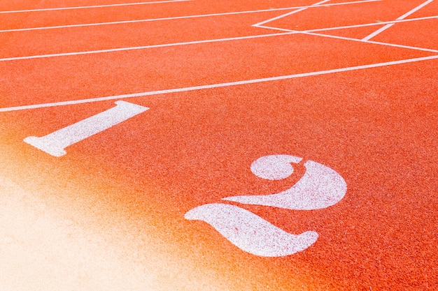 Genummerde startbaan in stadion Startlijn met nummers en rijstroken op de atletiekbaan in schoolstadiu