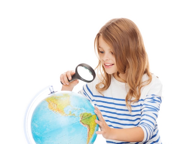 geography, education, people, children and school concept - little student girl looking at globe with magnifier