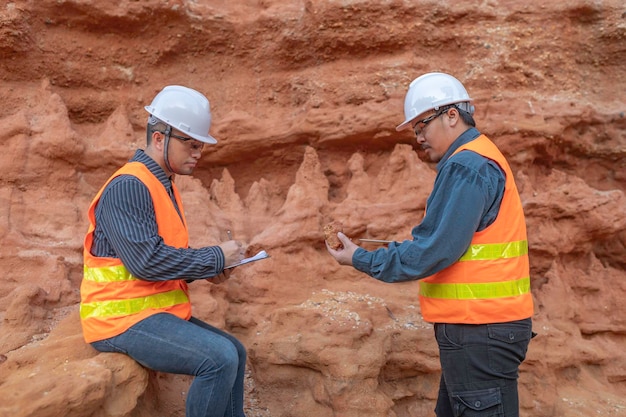 Geoloog die een mijn onderzoekt Ontdekers verzamelen bodemmonsters om naar mineralen te zoeken