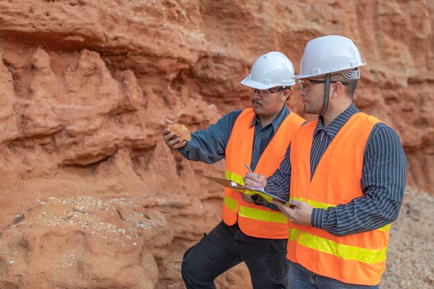 Geoloog die een mijn onderzoekt Ontdekers verzamelen bodemmonsters om naar mineralen te zoeken