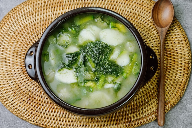 검은색 뚝배기에 담긴 한국 음식 메생이 떡국 요리