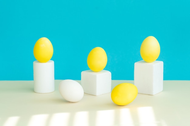 On geometric figures, as on a pedestal, there are yellow eggs