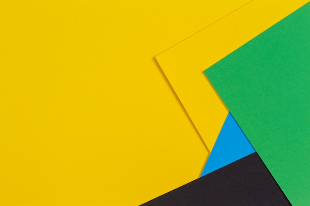 Parete di carta di colore giallo verde blu e nero a laici piatti geometrici